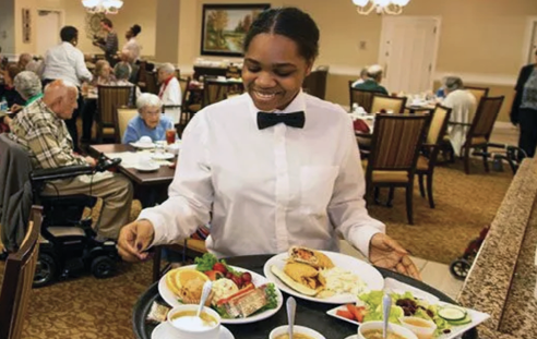 A woman in a restaurant serves food to a group of people. AI generated content