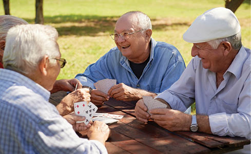 Four men are sitting around a table, playing cards. AI generated content