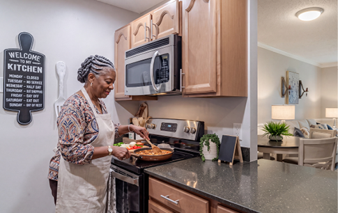 A woman is standing in a kitchen with a marble counter top. Description generated by AI